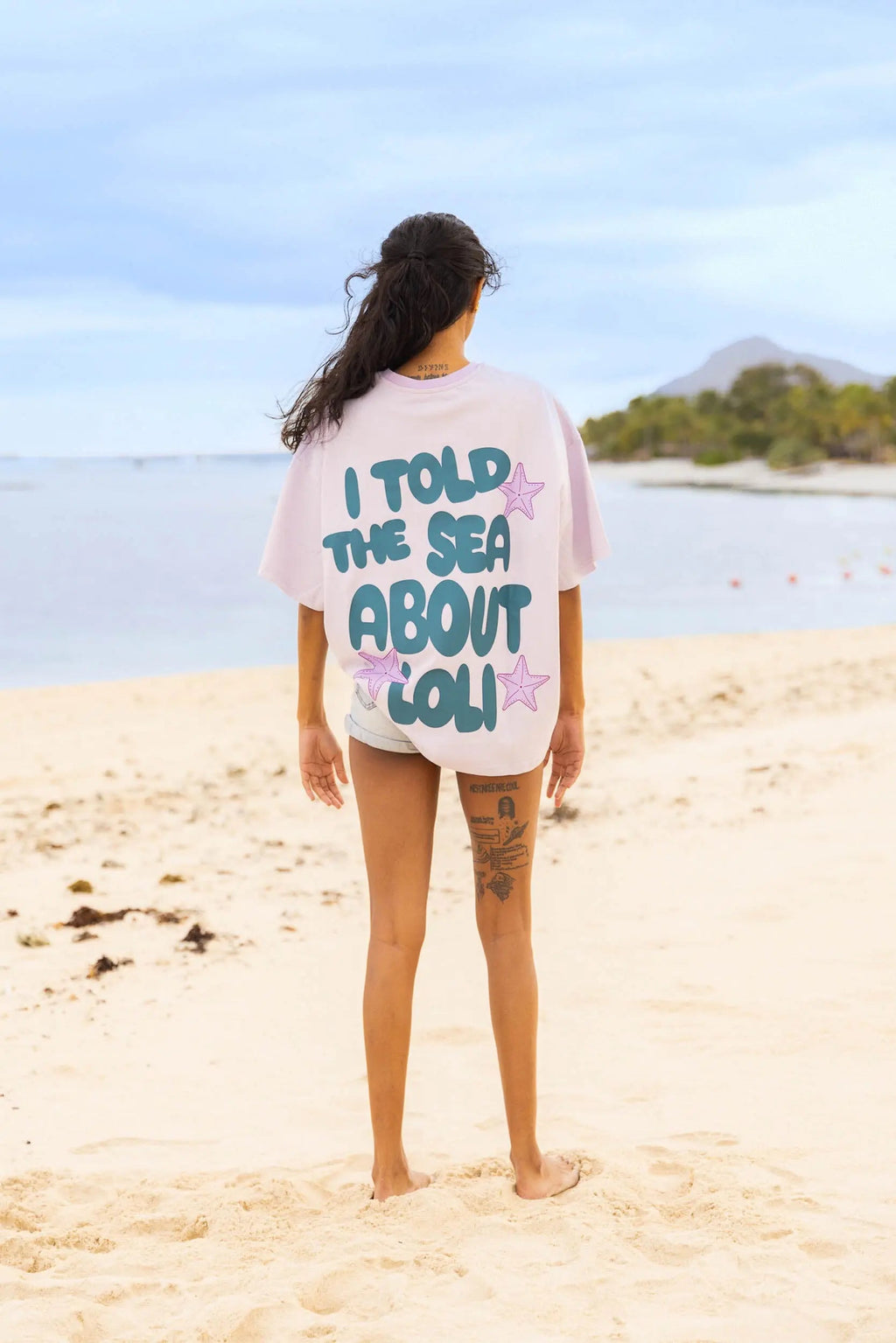 Femme de dos portant le t-shirt lila Loli Seaside avec grand imprimé coloré