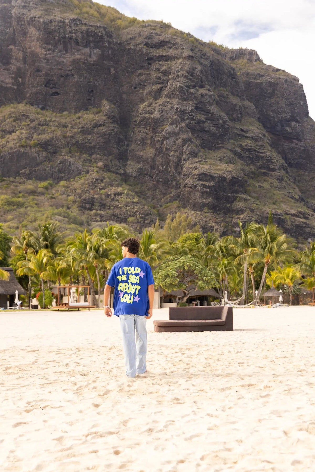 Homme portant le t-shirt bleu oversize Loli Seaside sur la plage